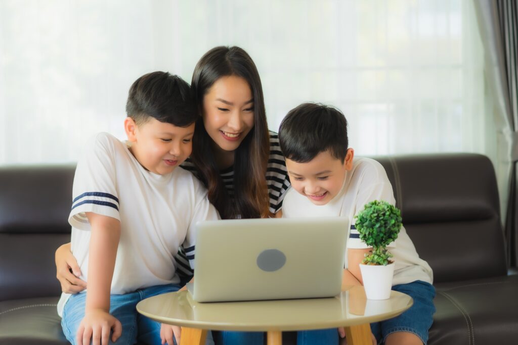 mae e dois filhos em frente ao computador